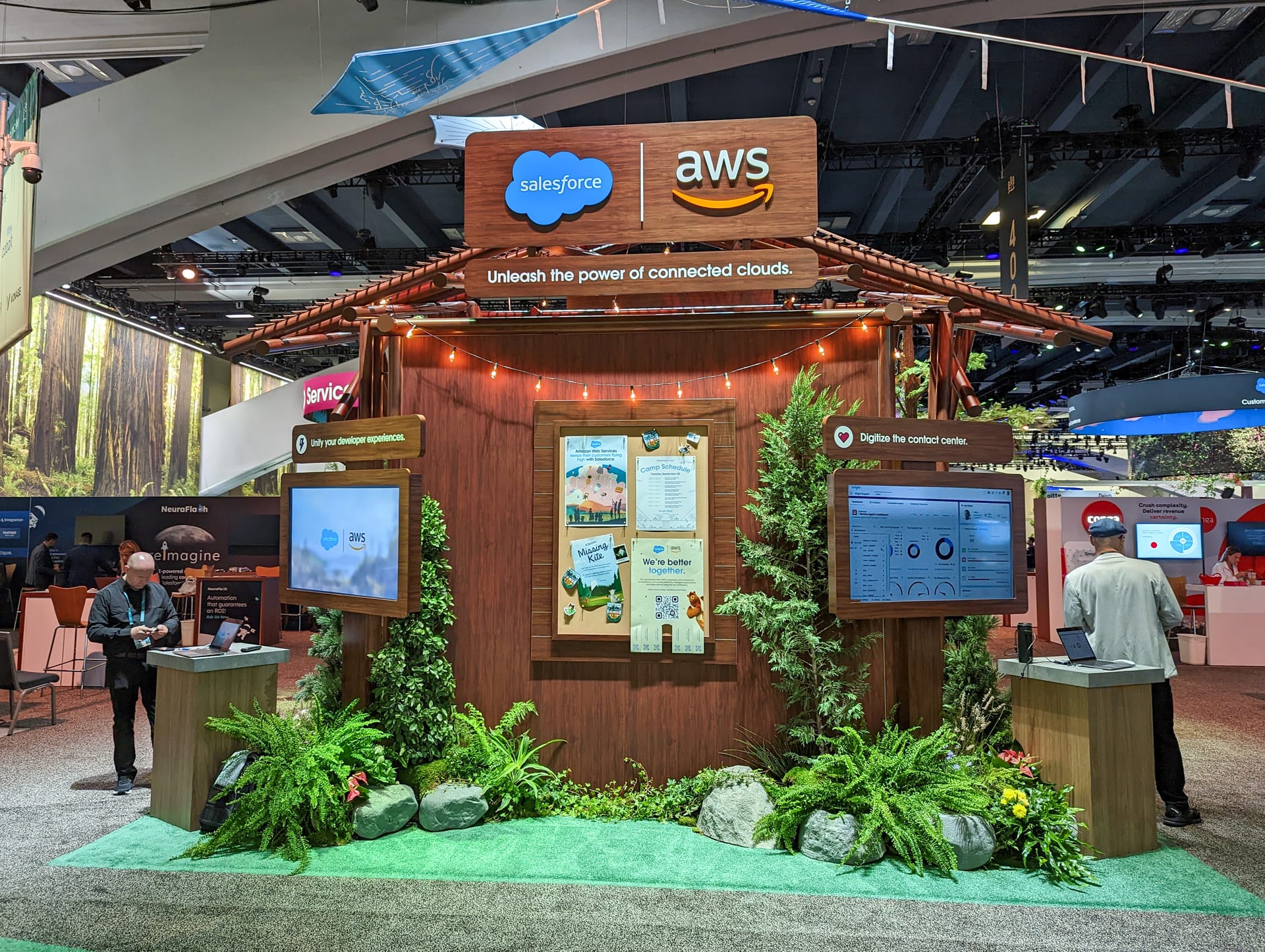 A wooden cabin-style partner pod on the Dreamforce 2022 campground, built out like a national park trailhead with a demo monitor inside