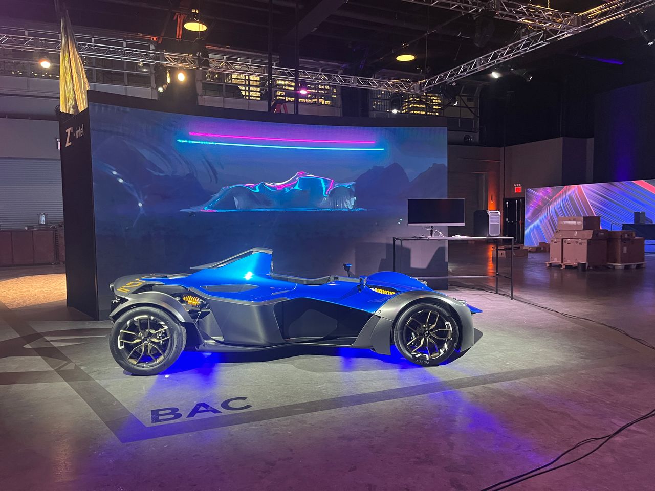 A blue BAC track car lit on a BAC floor graphic in front of a curved LED wall at the Z by HP Z8 Fury launch