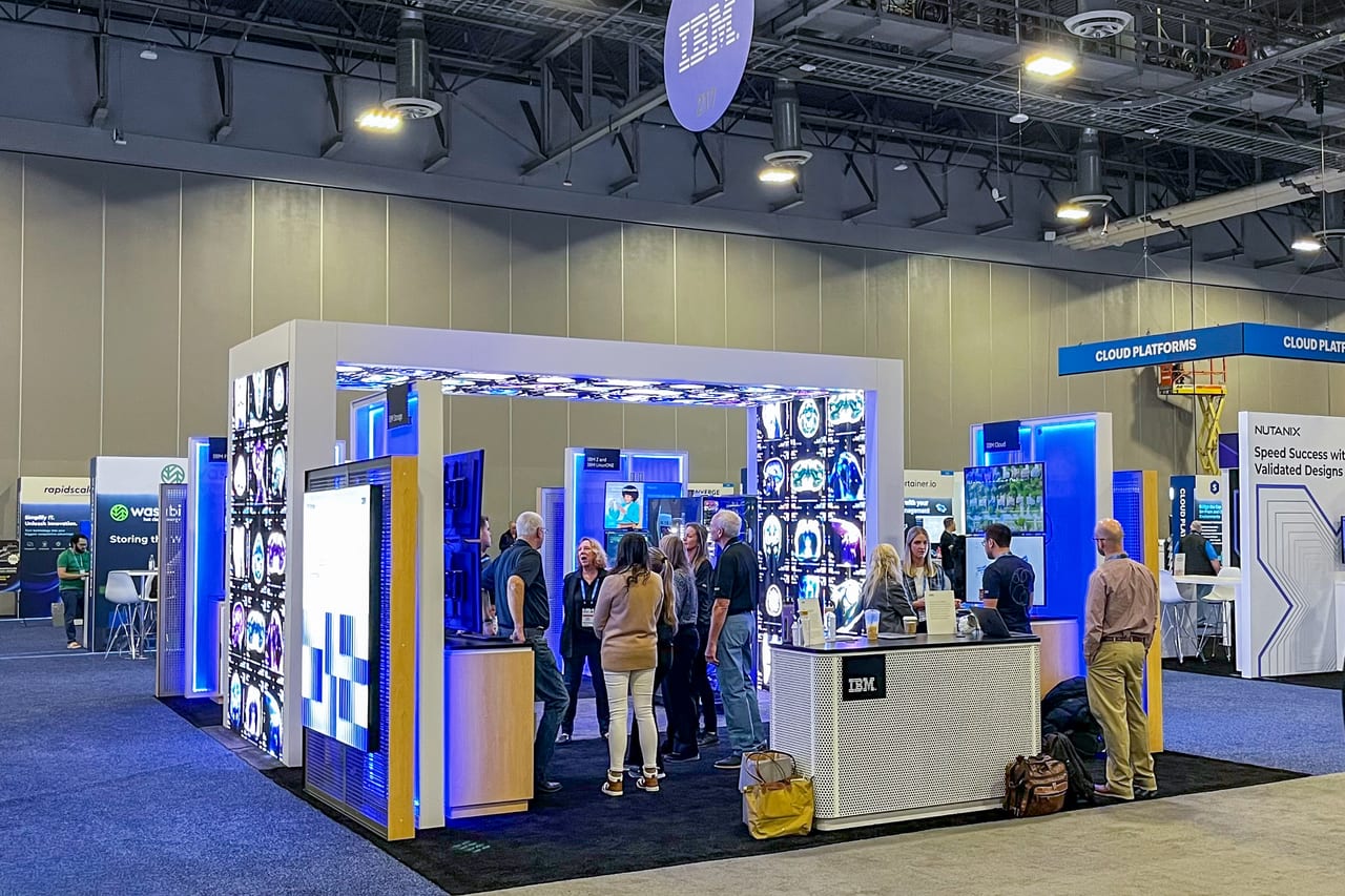 IBM's booth at Gartner IOCS 2023, a white portal arch with transparent LED columns and a glowing LED ceiling, full of attendees